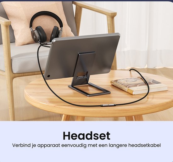 hoofdtelefoon aangesloten op tablet via lange kabel op houten tafel naast boek