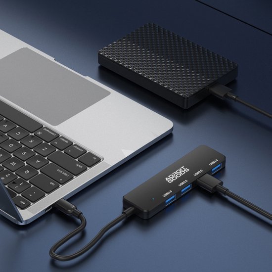Zwarte USB-hub met meerdere poorten aangesloten op laptop en externe harde schijf