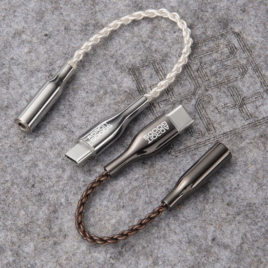 twee gevlochten audiokabels met usb-c connectors en metalen behuizing op een grijze ondergrond