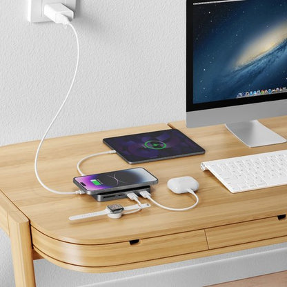 Draadloze oplader op houten bureau met smartphone, tablet, smartwatch en oordopjes in gebruik
