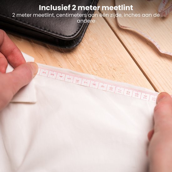 Hand meetlint van 2 meter gemeten over een witte stof op houten oppervlak naast zwart etui