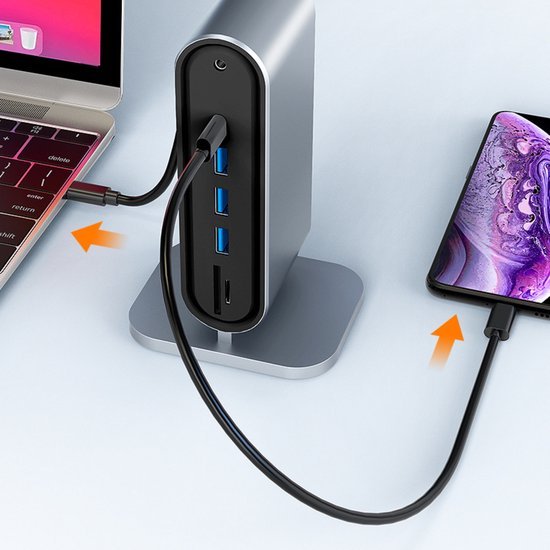 Laptop en smartphone verbonden met een aluminium USB-hub met meerdere poorten op een bureau