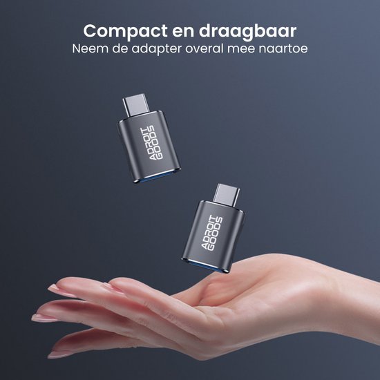 Compact en draagbare adapter zwevend boven open hand op donkerblauwe achtergrond