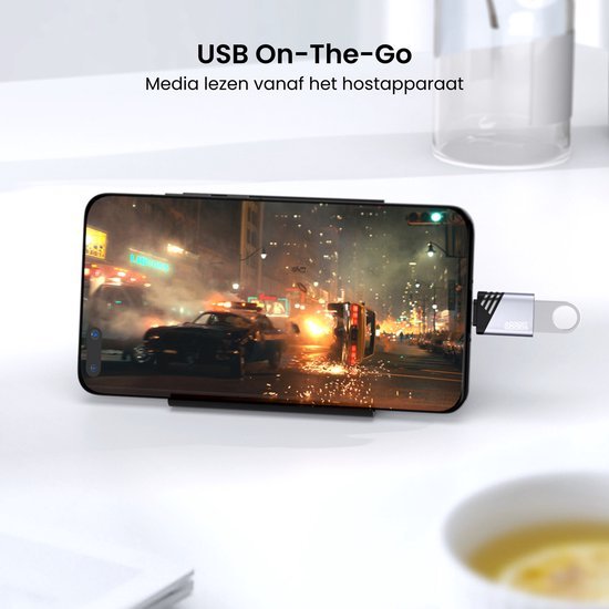 Smartphone liggend met USB-stick verbonden en filmpje van stad en auto's op scherm