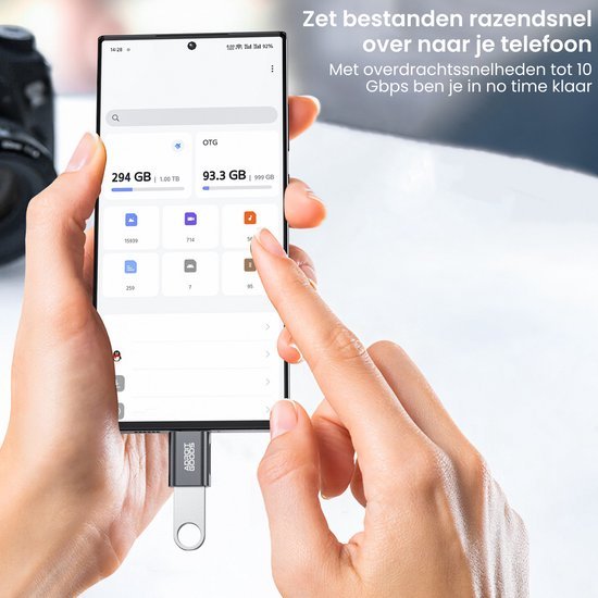 Hand houdt smartphone met aangesloten USB-stick en vinger wijst op scherm met bestandsbeheerapplicatie