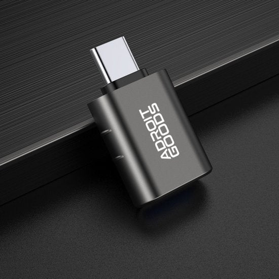USB-C naar USB-A adapter met metalen behuizing op donkere ondergrond