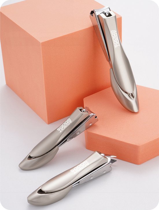 Drie metalen nagelknippers met een glanzende afwerking op oranje geometrische vormen