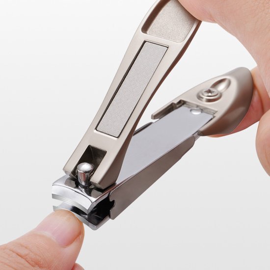 Hand die metalen nagelknipper vasthoudt en een nagel van een vinger knipt in close-up