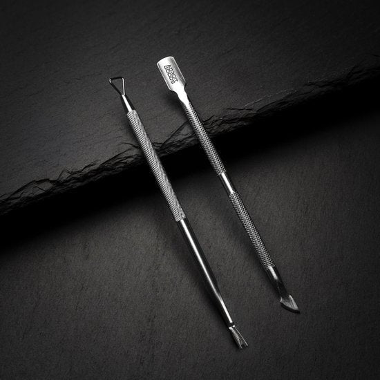 twee metalen manicure-instrumenten op een zwarte achtergrond, professioneel en strak vormgegeven
