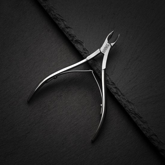 roestvrijstalen nagelknipper met scherpe punt op een donkere achtergrond