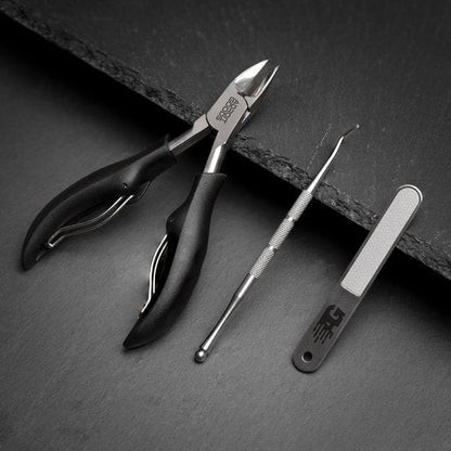Zwarte professionele nagelknipper, roestvrijstalen nagelreiniger en vijl op donkere ondergrond