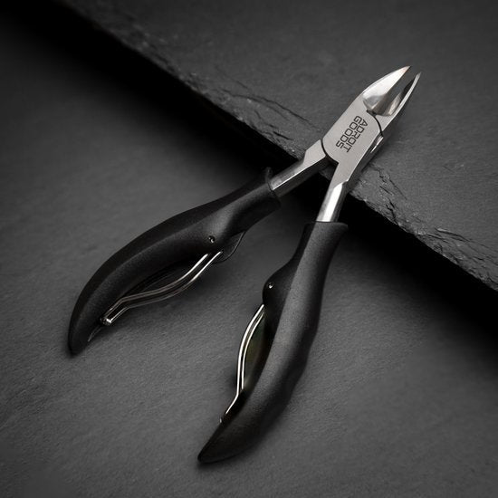 nagelknipper met zwarte handgrepen op donker oppervlak professioneel ontwerp