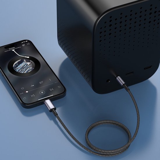 Zwarte smartphone verbonden met zwarte speaker via een gevlochten audiokabel op blauwe achtergrond