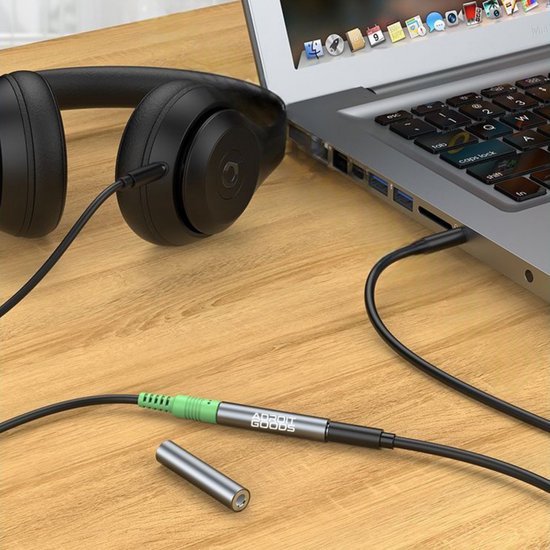 Zwarte koptelefoon verbonden met laptop via AdroitGoods geluidsadapter op houten tafel surface