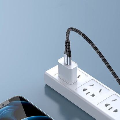 Zwart gevlochten oplaadkabel verbonden met witte stopcontactadapter en smartphone op blauw oppervlak