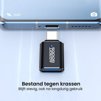 Zwarte AdroitGoods USB-C adapter verbonden met blauwe smartphone, krasbestendig en duurzaam design