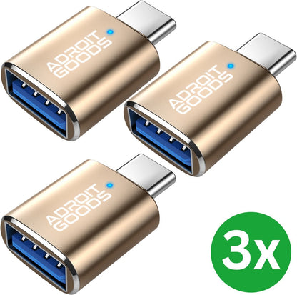 Drie gouden AdroitGoods USB-C naar USB 3.0 adapters met blauwe accenten naast groene 3x cirkel