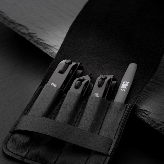 Set van vier zwarte nagelknippers en een vijl in een zwarte opbergrol van kunstleer