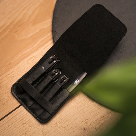 Zwart leren etui met vier georganiseerde gereedschappen op houten oppervlakte en grijze onderlaag