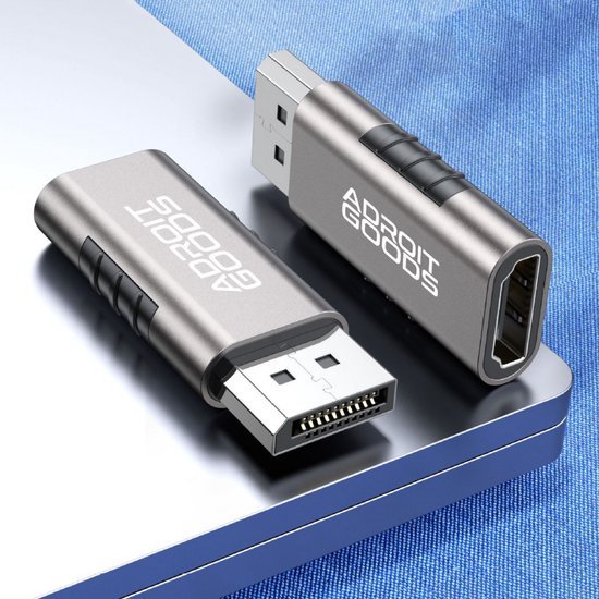 Twee metalen adapters met USB- en HDMI-aansluitingen liggen op een laptop met blauwe ondergrond.