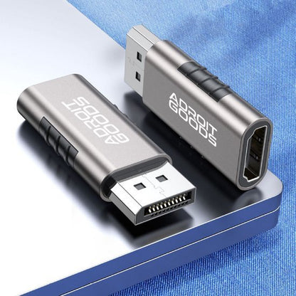 Twee metalen adapters met USB- en HDMI-aansluitingen liggen op een laptop met blauwe ondergrond.