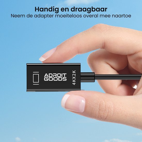 Hand houdt compacte AdroitGoods adapter vast tegen blauwe lucht met teksthandig en draagbaar