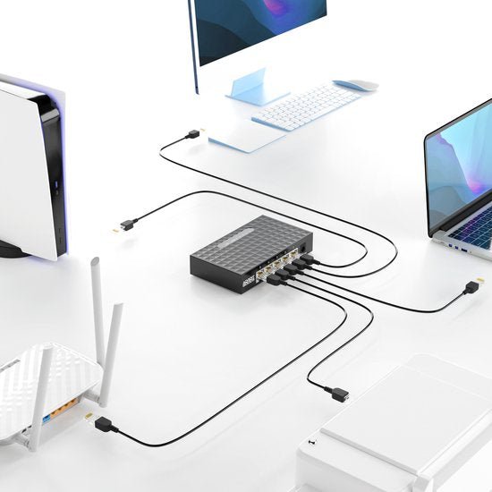 Zwarte netwerkswitch verbonden met diverse apparaten zoals laptop, desktop, printer en router.
