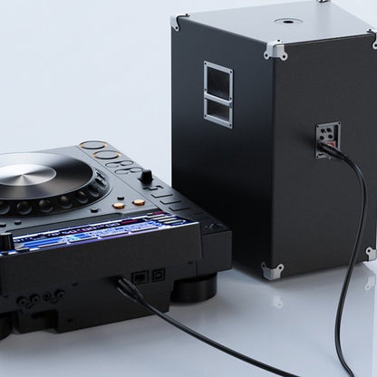 Zwarte DJ-controller verbonden met een zwarte luidspreker op een witte achtergrond.