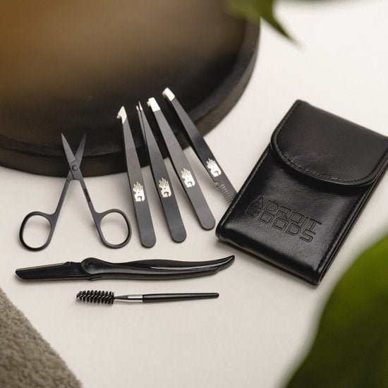 Set van professionele zwarte pincetten en schaartje met etui op witte ondergrond