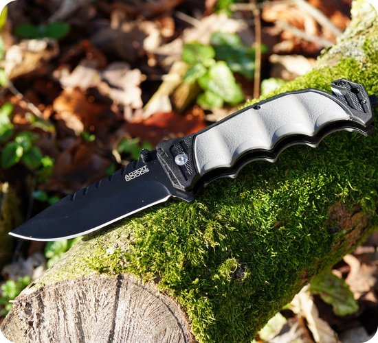 Opvouwbaar mes met zwarte lemmet en grijze antislip handgreep op mosbeslagen boomstam