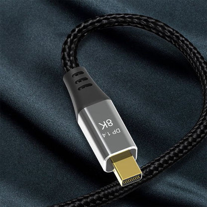 Zwarte gevlochten kabel met zilveren connector en gouden contactpunten op donkere achtergrond