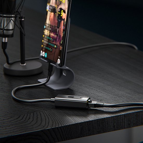 Moderne opstelling met smartphone in standaard en aangesloten kabeladapter op zwart bureau