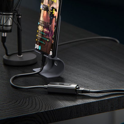 Moderne opstelling met smartphone in standaard en aangesloten kabeladapter op zwart bureau