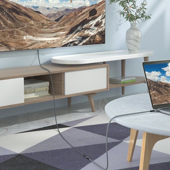 modern woonkamer met houten meubel, laptop en natuurbeelden op tv en tafelblad