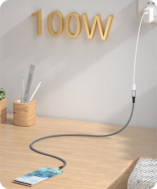 Smartphone op houten tafel verbonden met een grijze laadkabel aan een wandcontactdoos