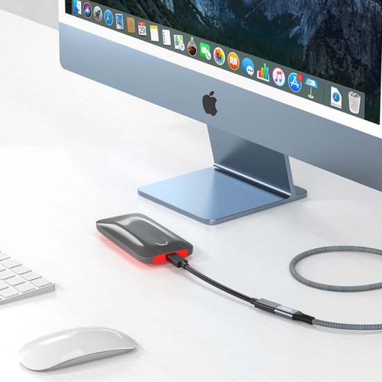extern opslagapparaat met kabel aangesloten op een desktopcomputer op een wit bureau