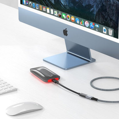 extern opslagapparaat met kabel aangesloten op een desktopcomputer op een wit bureau