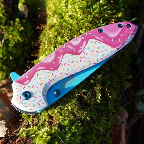 Vouwmes met kleurrijk ijsjessneeuwvlokpatroon liggend op groene mosgrond