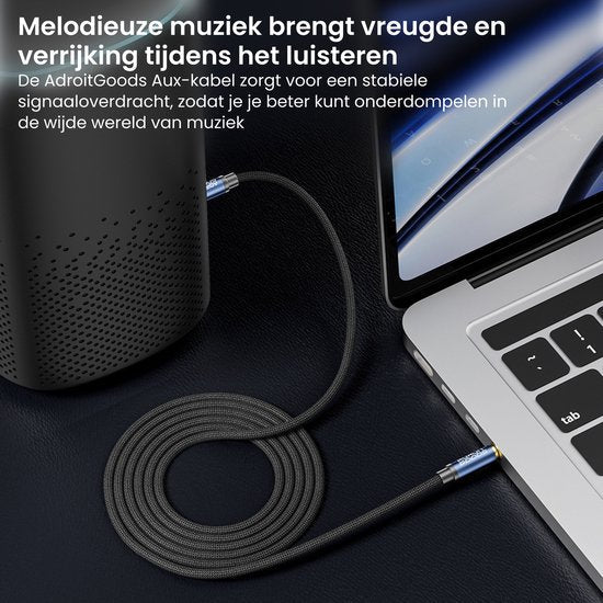 Zwarte gevlochten Aux-kabel verbonden met laptop en speaker op een donkere ondergrond