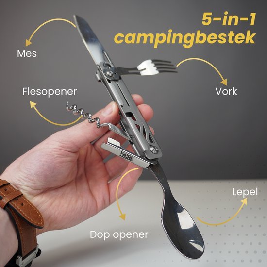 Hand die multifunctioneel 5-in-1 campingbestek vasthoudt met mes, vork, lepel, fles- en dopopener.