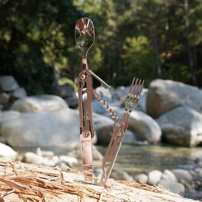 Multifunctioneel bestek met lepels, vorken en een kurkentrekker in natuurlijke buitenomgeving