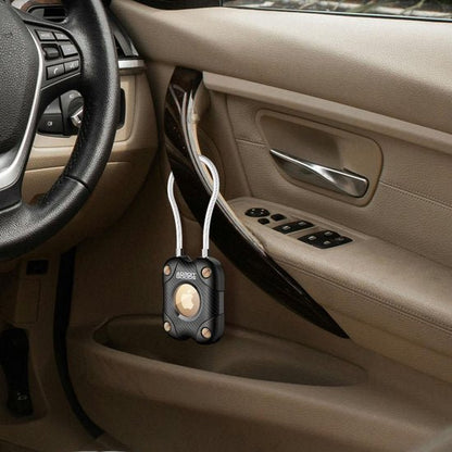 Zwart beschermhoesje voor sleutelhanger met koord in een beige autodeurpaneel