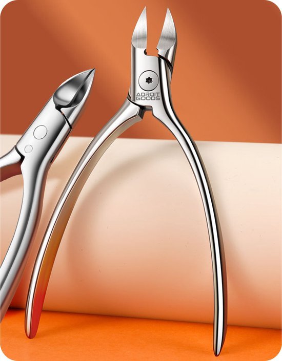 Twee metalen manicure knipgereedschappen op een oranje en beige achtergrond staand.