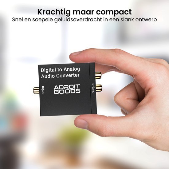 Hand houdt compacte digitale naar analoge audio converter met input en output aansluitingen.