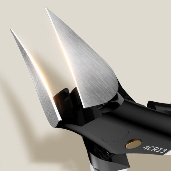 Detail van scherp roestvrijstalen blad met zwarte handgreep en gouden schroefverbinding