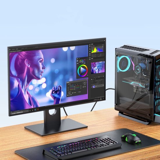 Moderne computer op bureau met kleurrijke gaming muis en toetsenbord naast een beeldbewerking scherm