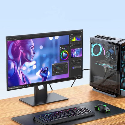 Moderne computer op bureau met kleurrijke gaming muis en toetsenbord naast een beeldbewerking scherm