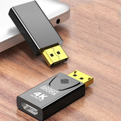 Zwarte 4K Ultra HD adapter met goudkleurige connectors op houten tafel naast laptop