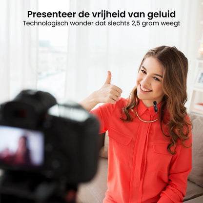 Vrolijke vrouw met draadloze microfoon geeft duim omhoog tijdens opname in lichte kamer