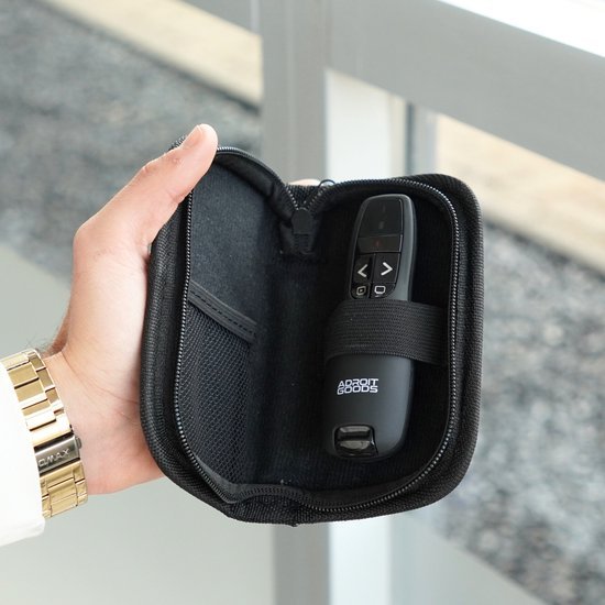 hand die een zwart opbergetui vasthoudt met een AdroitGoods afstandsbediening erin